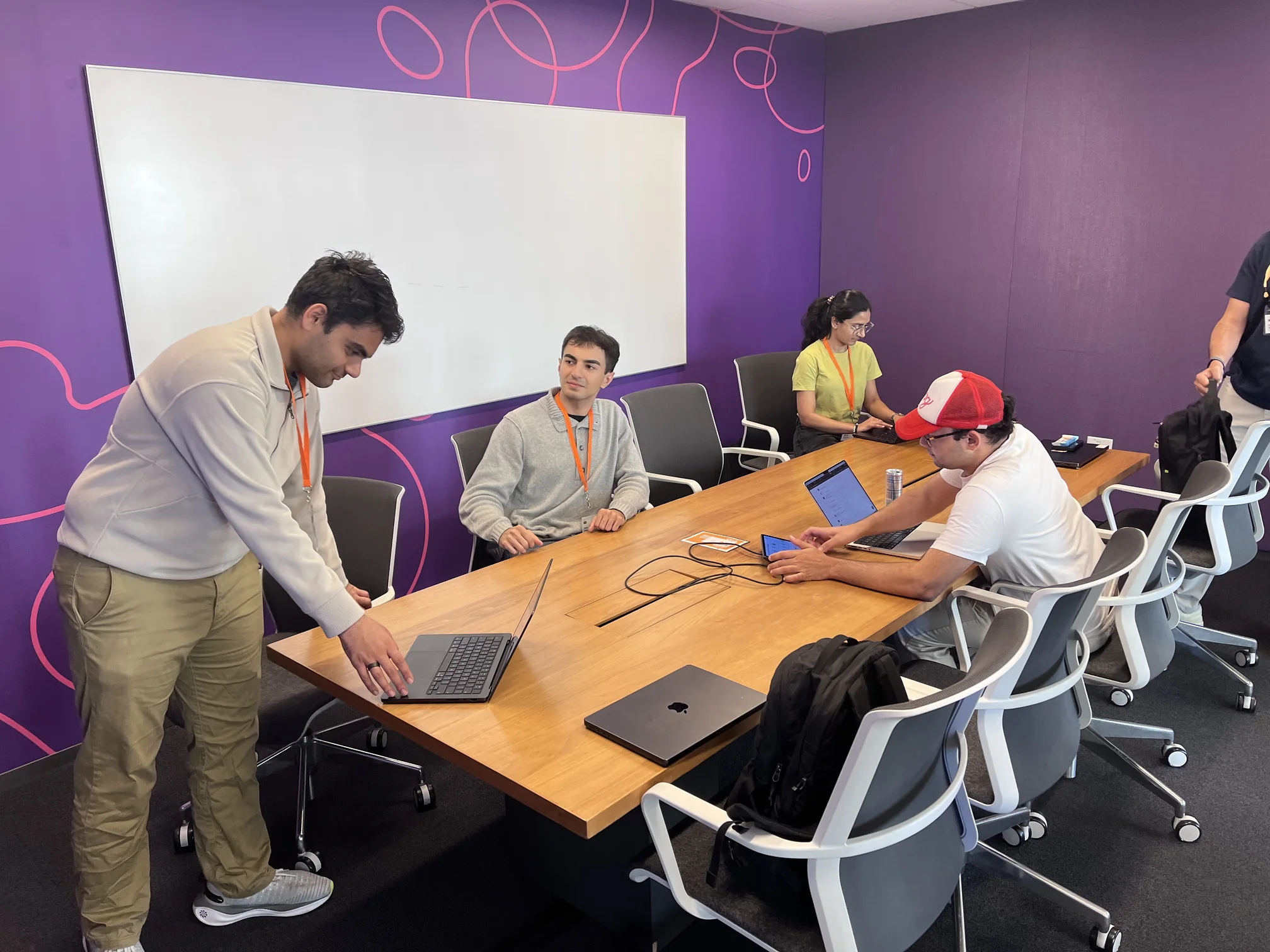 A team gathered around a laptop in a meeting room